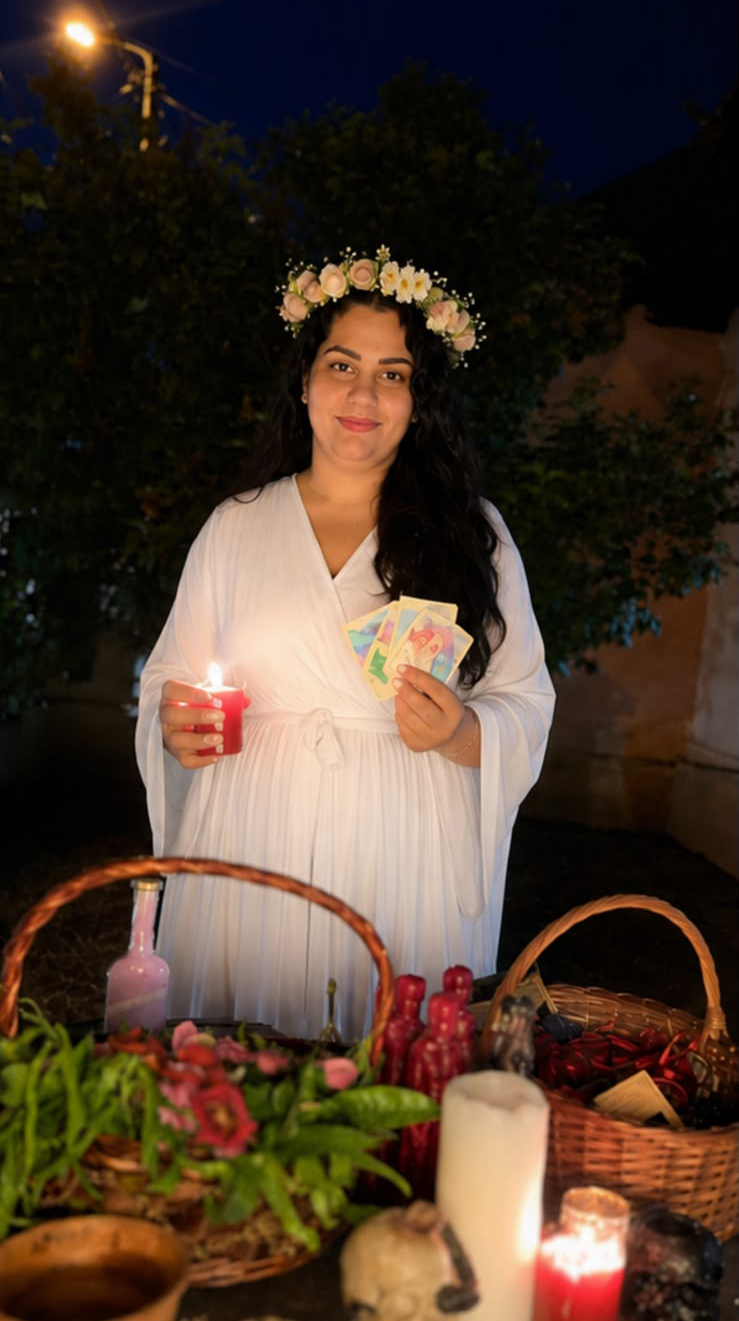 Vrăjitoarea Lavinia în veșmânt alb, cu lumânare aprinsă, pregătind un ritual în noapte